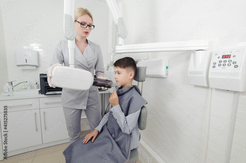 Dentist hands make jaw x-ray image for little boy in dental clinic Dentist hands make jaw x-ray image for little boy in dental clinic