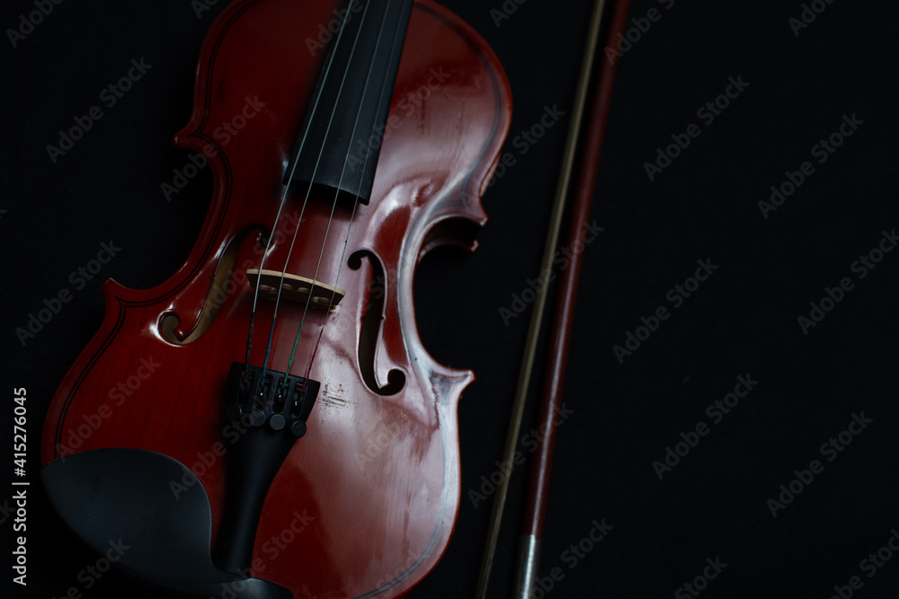 Close view of a classical small violin, strings and bridge over a dark black blanket background
Close view of a classical small violin, strings and bridge over a dark black blanket background