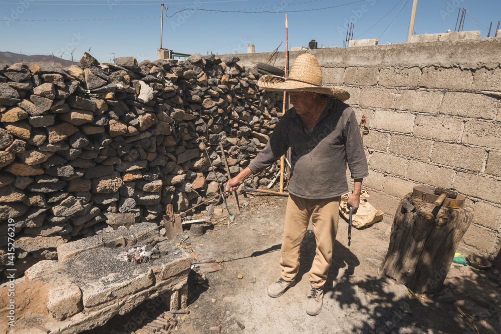 Blacksmith working in the forge with incandescent metal to create chisels by striking the metal into the tool. Blacksmith working in the forge with incandescent metal to create chisels by striking the metal into the tool.