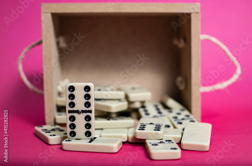 Old fashioned dirty domino on a box with pink solid backround
