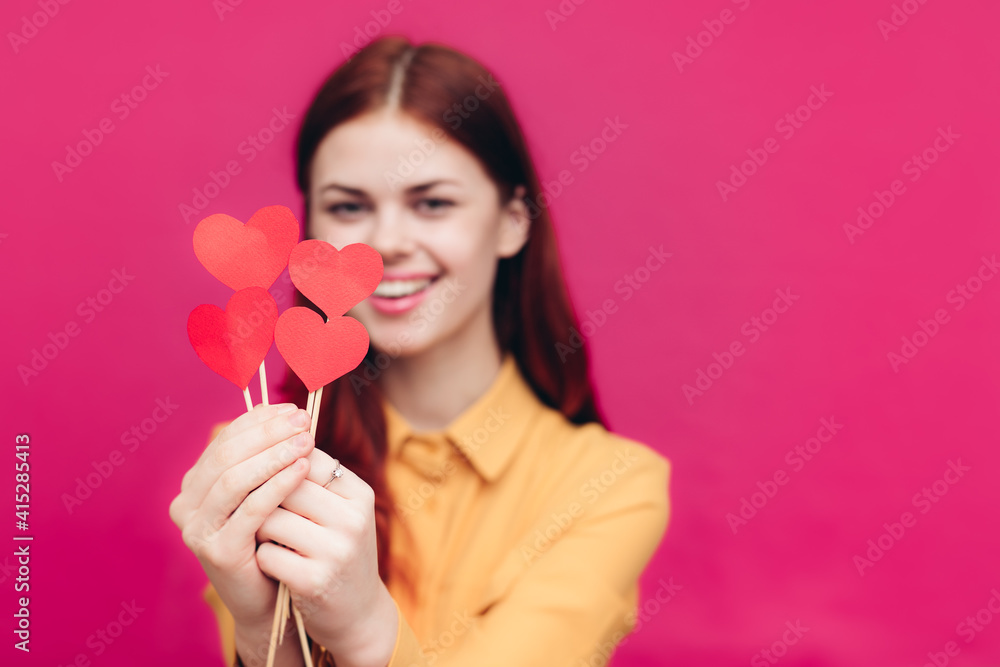emotional woman with paper hearts on a stick on a pink background and Valentine's Day emotional woman with paper hearts on a stick on a pink background and Valentine's Day
