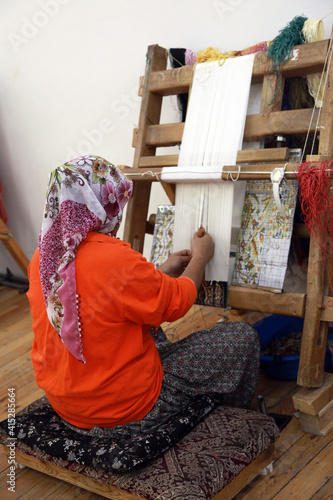 A woman making Traditional Turkish Carpet at Cappadocia in Nevsehir, Turkey. photo