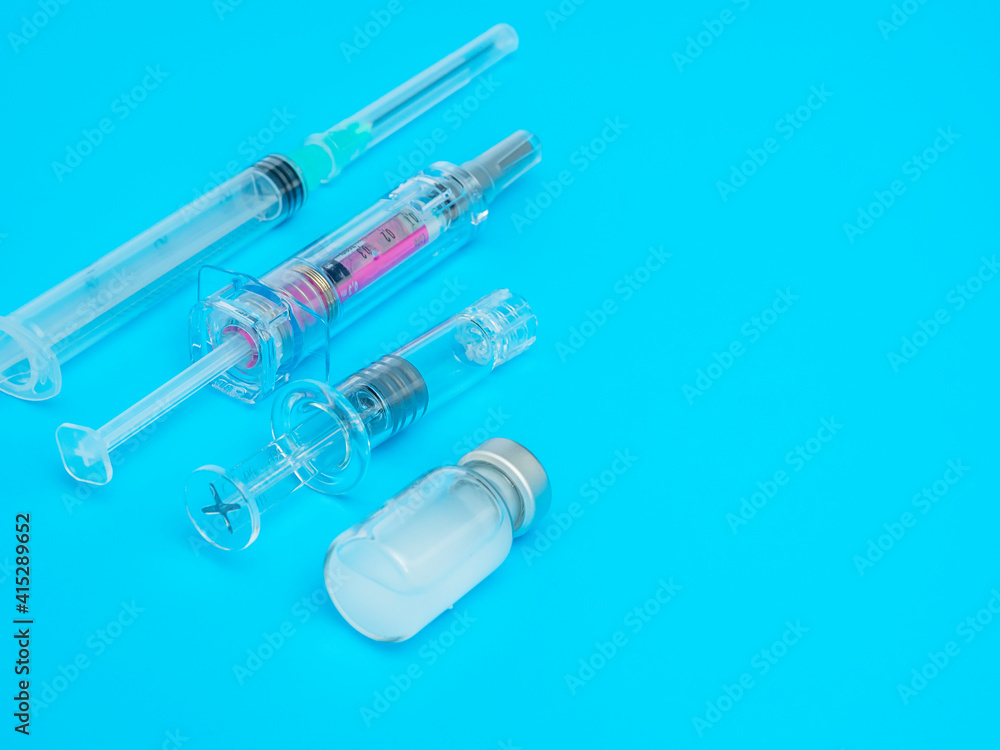 Group of syringes and vaccine on blue background. Copy space. Vaccination concept. Group of syringes and vaccine on blue background. Copy space. Vaccination concept.