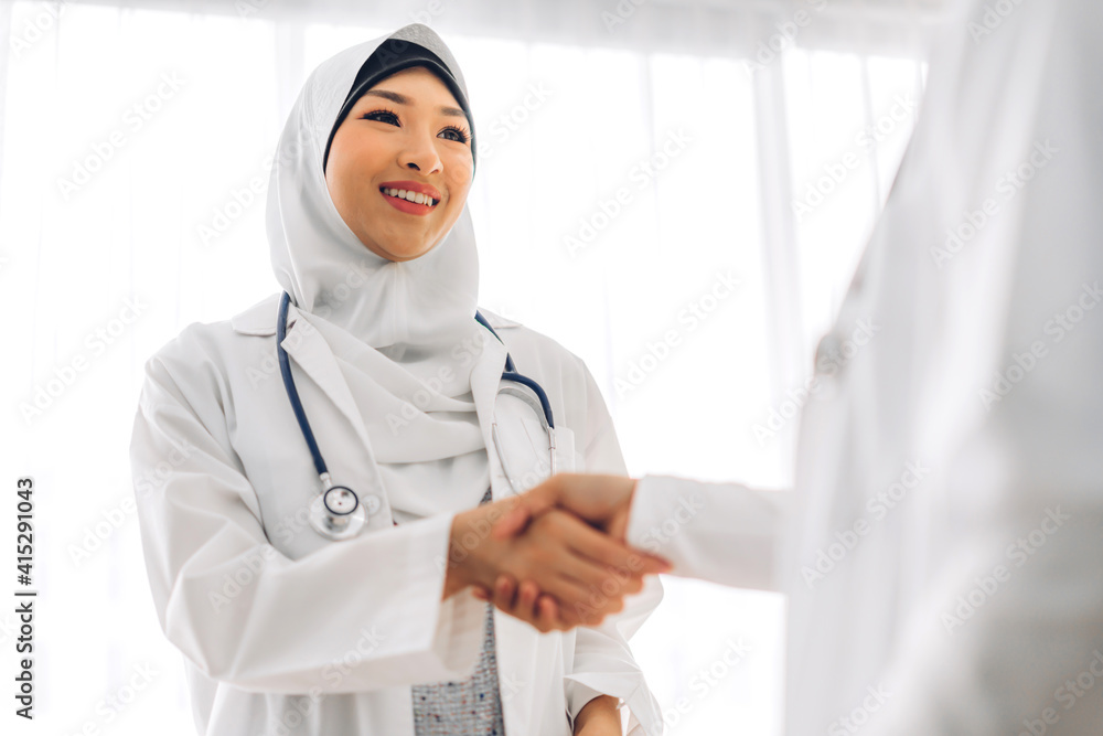 Success of smiling two muslim asian partners woman doctor handshake together.Professional muslim doctor meeting and shaking hands in hospital.healthcare and medicine Success of smiling two muslim asian partners woman doctor handshake together.Professional muslim doctor meeting and shaking hands in hospital.healthcare and medicine