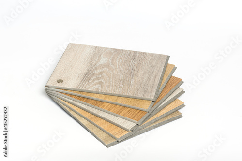Stack of sample PVC vinyl wood planks on white background.