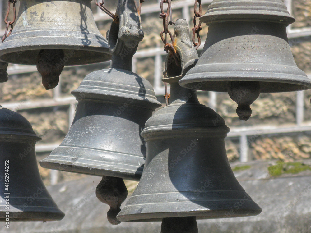 Bells made of various metals hanging side by side outside Hindu Temples 