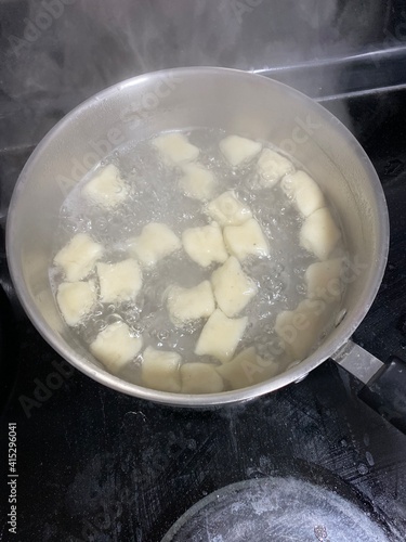 hand rolled gnocchi boiling in large pot on stove top