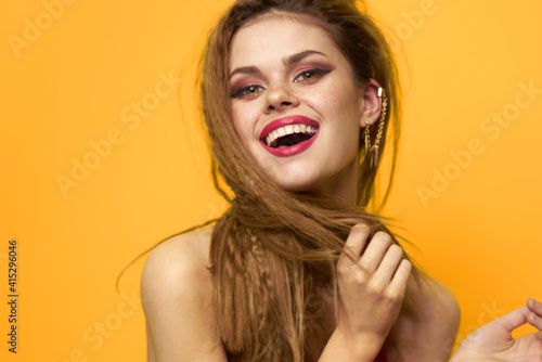 Pretty woman wavy hair red tank top fashion lifestyle cosmetics yellow background