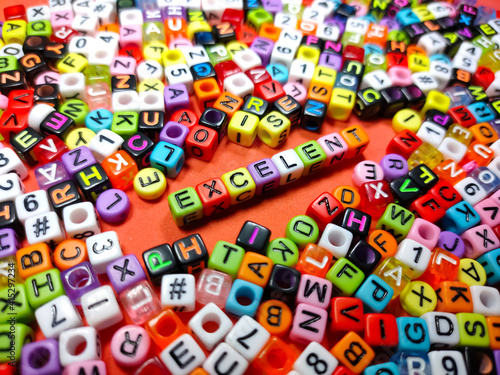 Selective focus.Colorful dice with word EXCELENT on red background.Shot were noise and film grain.