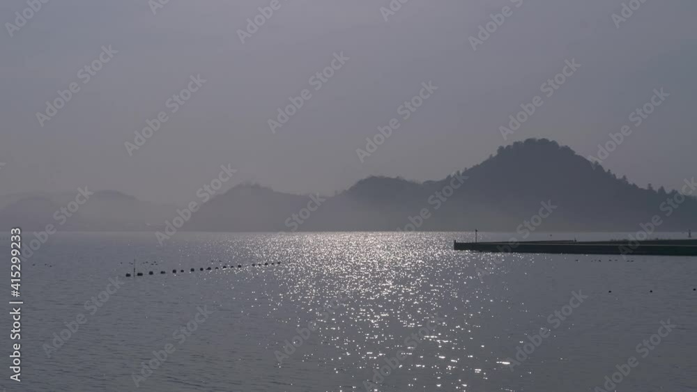 霧にかすむ山と日光が反射する海 霧にかすむ山と日光が反射する海