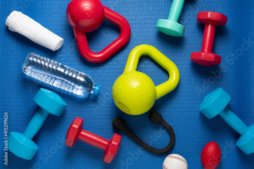 Fotografie Time for exercising sport equipment, dumbbell, kettlebell with blue yoga mat bac