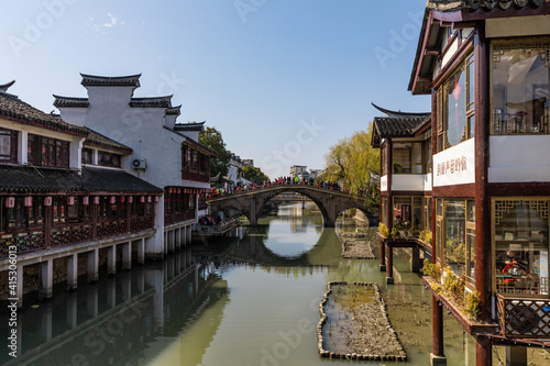 View of Puhui River, traditional tea houses on both sides, historic Puhuitang or Tang Bridge with massive tourists in Old Street in Qibao Old Town, Minhang District, Shanghai, China.