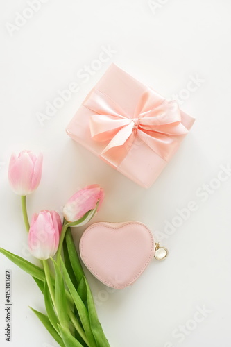 Holiday background. pink tulip flowers, pink heart gift box top view on white background. Valentine's da, Birthday, Women's day, Mother's day backdrop. Flat lay.