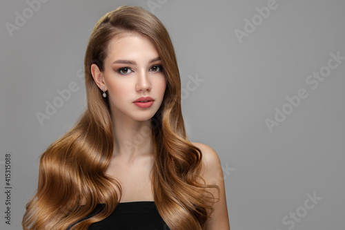 Long beautiful wavy hair. Portrait of a woman with shiny blond hair. copycpase