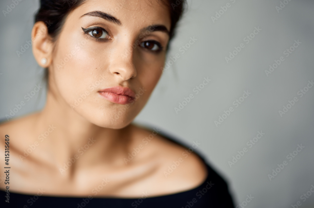 romantic lady in evening dress and earrings on a gray background portrait close-up romantic lady in evening dress and earrings on a gray background portrait close-up