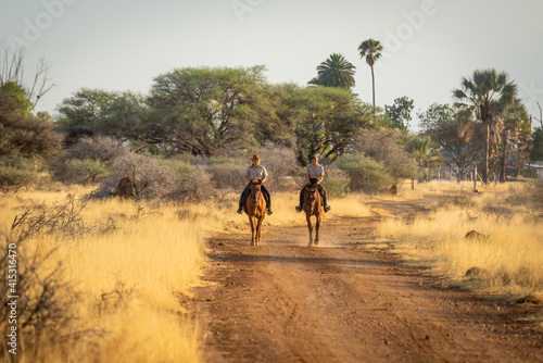 Two women ride side-by-side along dirt track © Nick Dale
