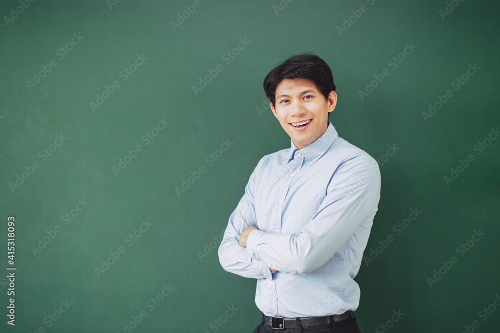 young smiling teacher standing in front of chalkboard young smiling teacher standing in front of chalkboard