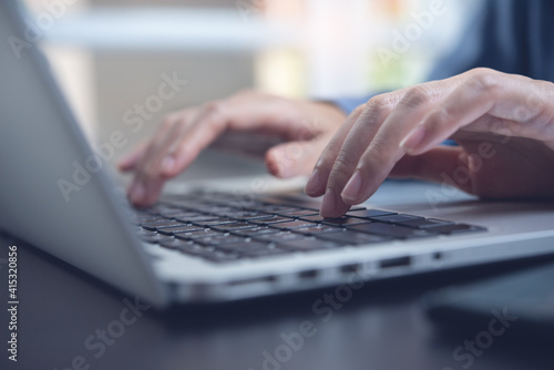 Close up of woman hands typing on laptop computer online working from home office
