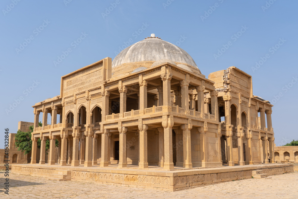 Landscape view of ancient mughal era carved sandstone tomb of Isa Khan Tarkhan II in UNESCO listed Makli necropolis, Thatta, Sindh, Pakistan