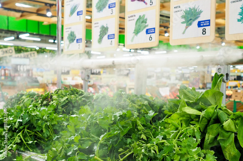 Kitchen herbs in supermarket baskets with steam irrigation system to keep vegetables fresh. photo