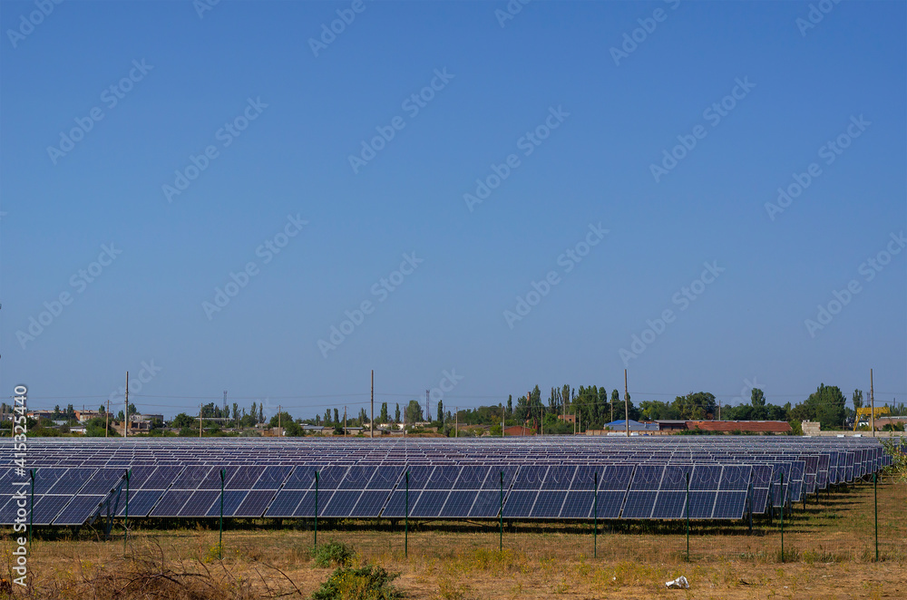 A solar power plant against the backdrop of a small residential community.