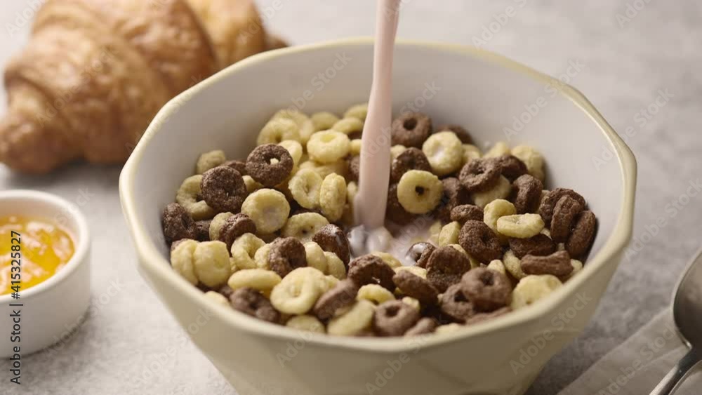 A plate of chocolate and vanilla cornflakes is filled with milk A plate of chocolate and vanilla cornflakes is filled with milk