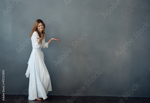 Woman in white dress glamor dance gray background