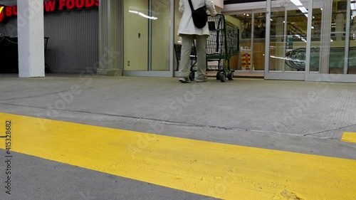 Wallpaper Mural Close up woman pushing shopping cart walking on the yellow sidewalk going to buy low foods supermarket Torontodigital.ca