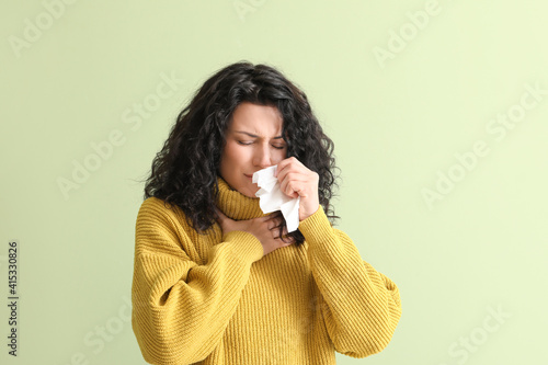 Sick young woman on color b...
