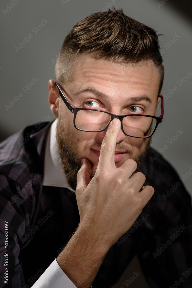 Portrait of young handsome smart man correcting glasses Portrait of young handsome smart man correcting glasses