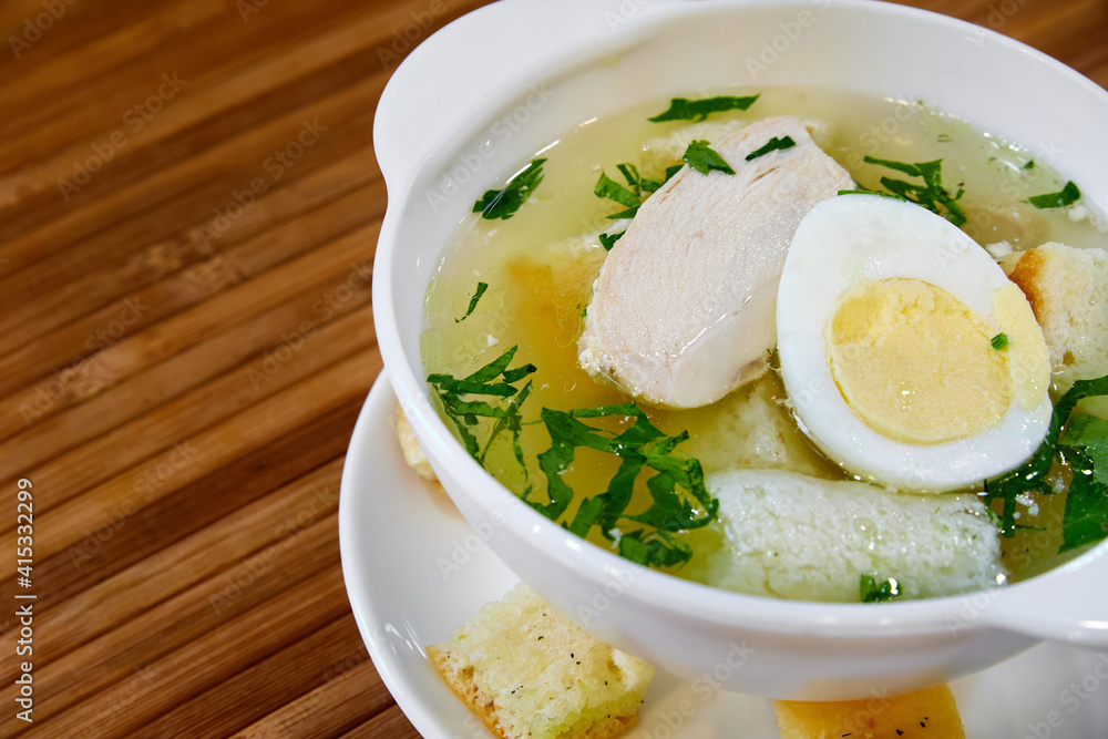 Broth with chicken fillet, egg, croutons and herbs. Close-up, selective focus Broth with chicken fillet, egg, croutons and herbs. Close-up, selective focus