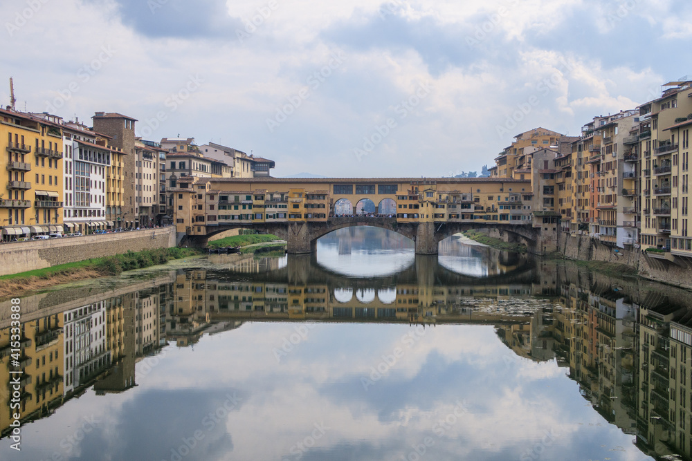 Obraz premium A snapshot with the Ponte Vecchio in the background with its reflection projected on the Arrno river, Firenze, Italy 