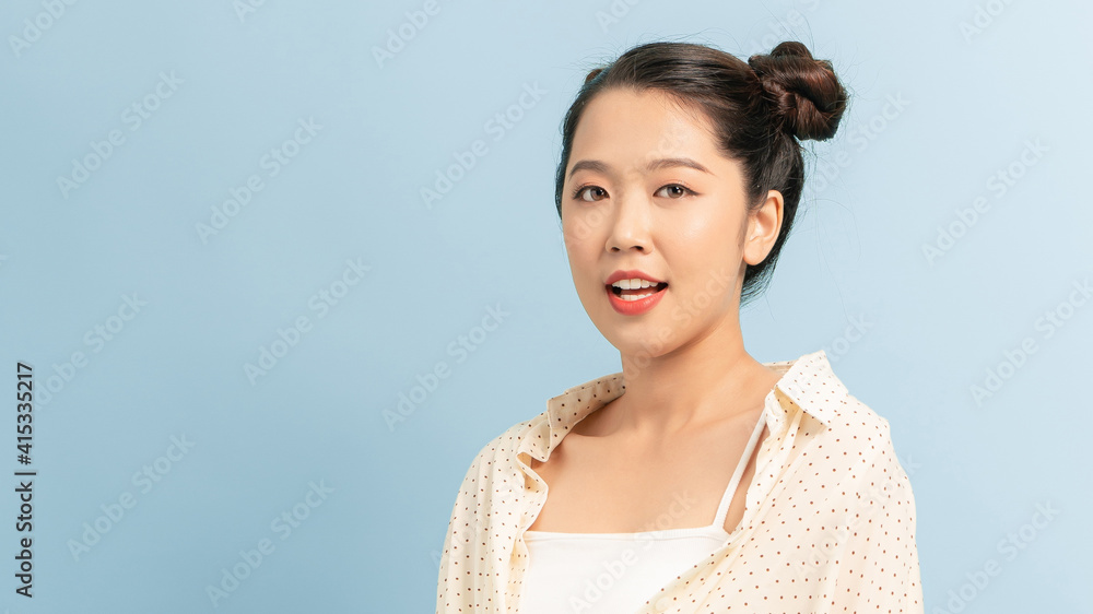 Portrait of beautiful young Asian woman on blue background Portrait of beautiful young Asian woman on blue background