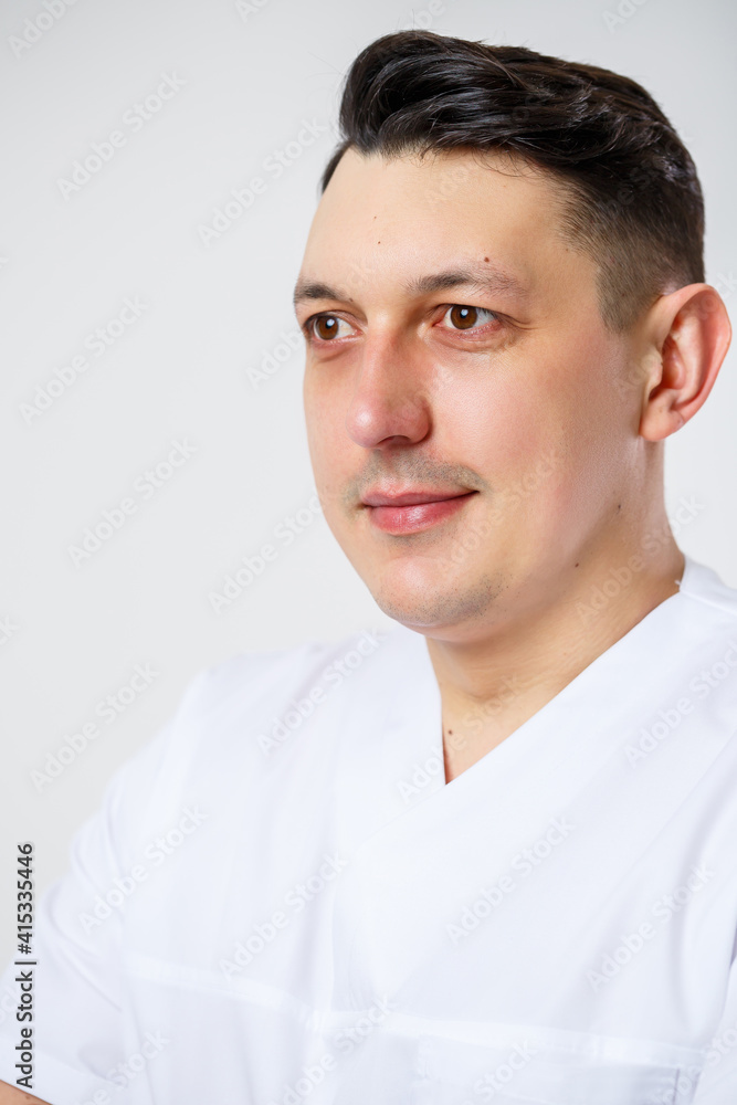 Young male doctor in a white surgical suit.Isolated on a white background Young male doctor in a white surgical suit.Isolated on a white background
