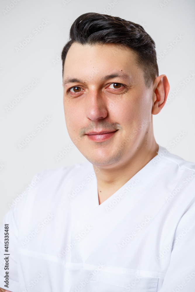 Young male doctor in a white surgical suit.Isolated on a white background Young male doctor in a white surgical suit.Isolated on a white background