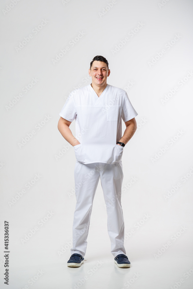 Young male doctor in a white surgical suit.Isolated on a white background Young male doctor in a white surgical suit.Isolated on a white background