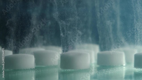 close-up of white tablets in water dissolving photo