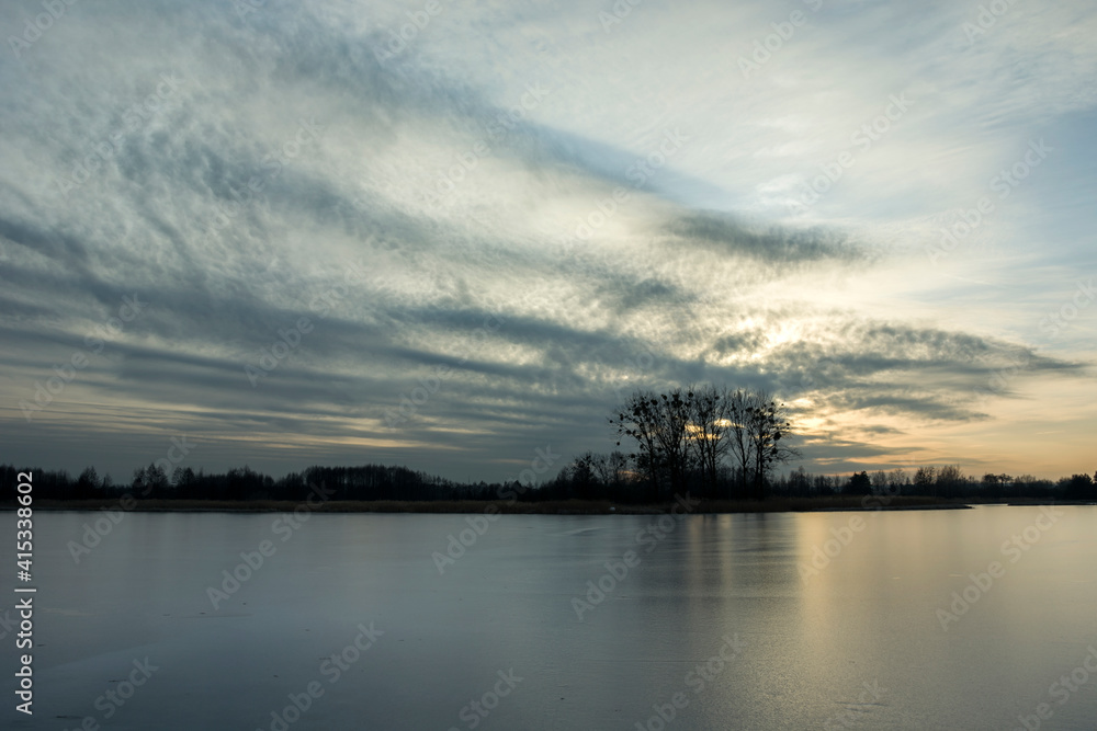 The surface of the frozen lake and clouds after sunset