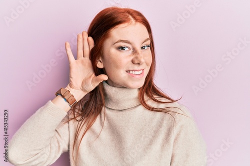 Εκτύπωση καμβά Young red head girl wearing turtleneck sweater smiling with hand over ear listening and hearing to rumor or gossip