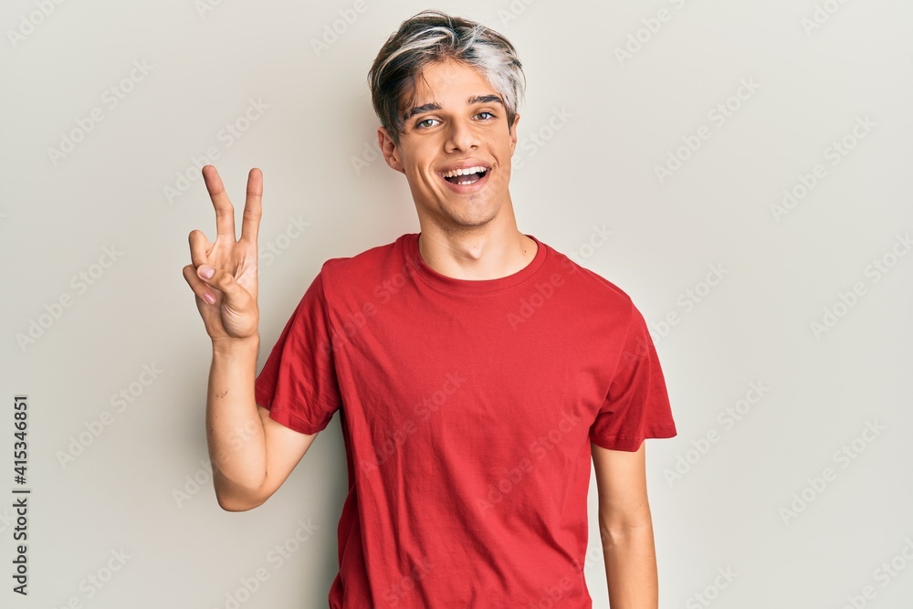Young hispanic man wearing casual clothes smiling looking to the camera showing fingers doing victory sign. number two. Young hispanic man wearing casual clothes smiling looking to the camera showing fingers doing victory sign. number two.