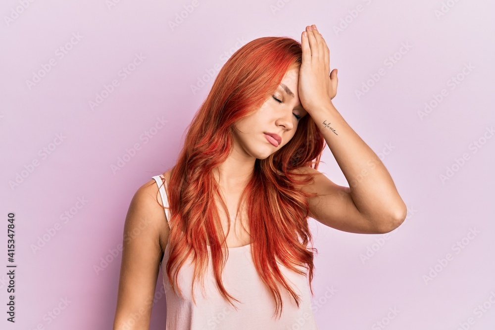 Young beautiful redhead woman wearing casual clothes over pink background surprised with hand on head for mistake, remember error. forgot, bad memory concept. Young beautiful redhead woman wearing casual clothes over pink background surprised with hand on head for mistake, remember error. forgot, bad memory concept.