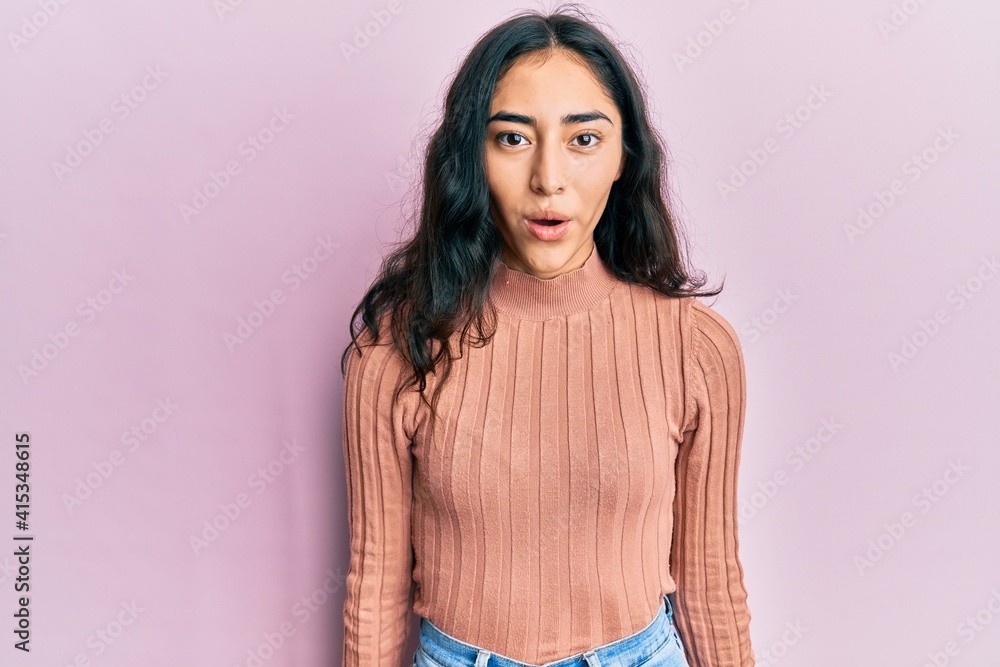 Obraz premium Hispanic teenager girl with dental braces wearing casual clothes scared and amazed with open mouth for surprise, disbelief face