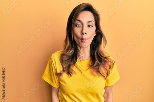Young latin woman wearing casual clothes making fish face with lips, crazy and comical gesture. funny expression.