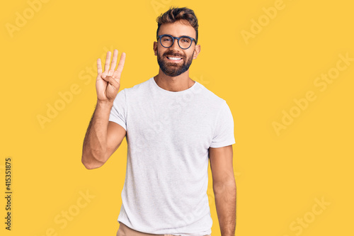 Young hispanic man wearing casual clothes and glasses showing and pointing up with fingers number four while smiling confident and happy.