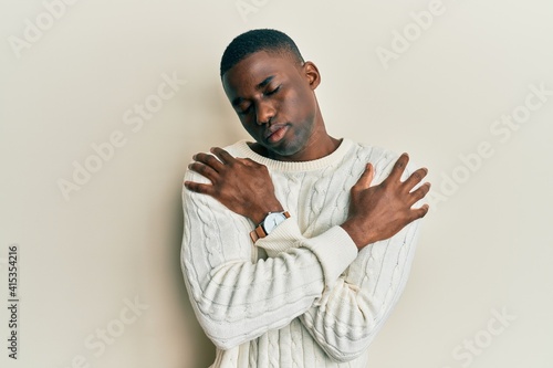 Young african american man wearing casual clothes hugging oneself happy and positive, smiling confident. self love and self care