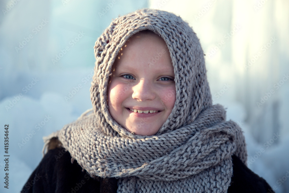 Portrait of a little girl in a headscarf in winter.