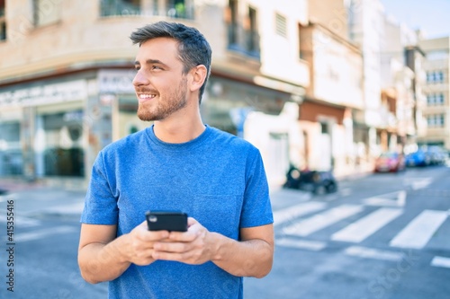 Young caucasian man smiling happy using smartphone at the city. © Krakenimages.com