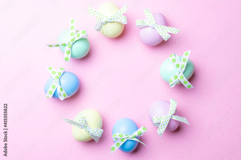 Easter border. Colorful egg with tape ribbon on pastel pink background in Happy Easter decoration. Flat lay, top view.