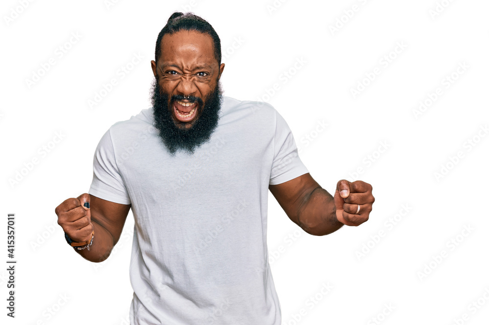 Young african american man wearing casual white tshirt very happy and excited doing winner gesture with arms raised, smiling and screaming for success. celebration concept. Young african american man wearing casual white tshirt very happy and excited doing winner gesture with arms raised, smiling and screaming for success. celebration concept.