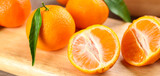 Delicious fresh tangerines on wooden board, closeup